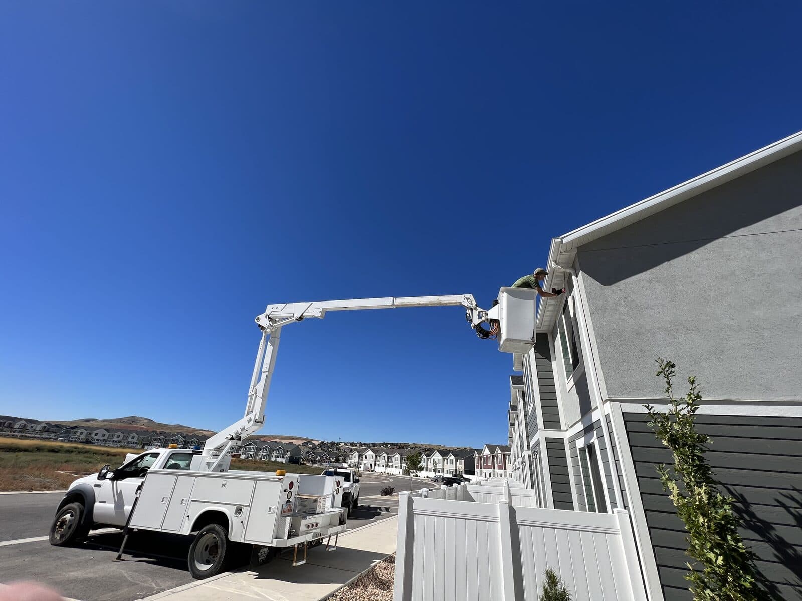 Boom lift working townhome fascia for bat exclusion