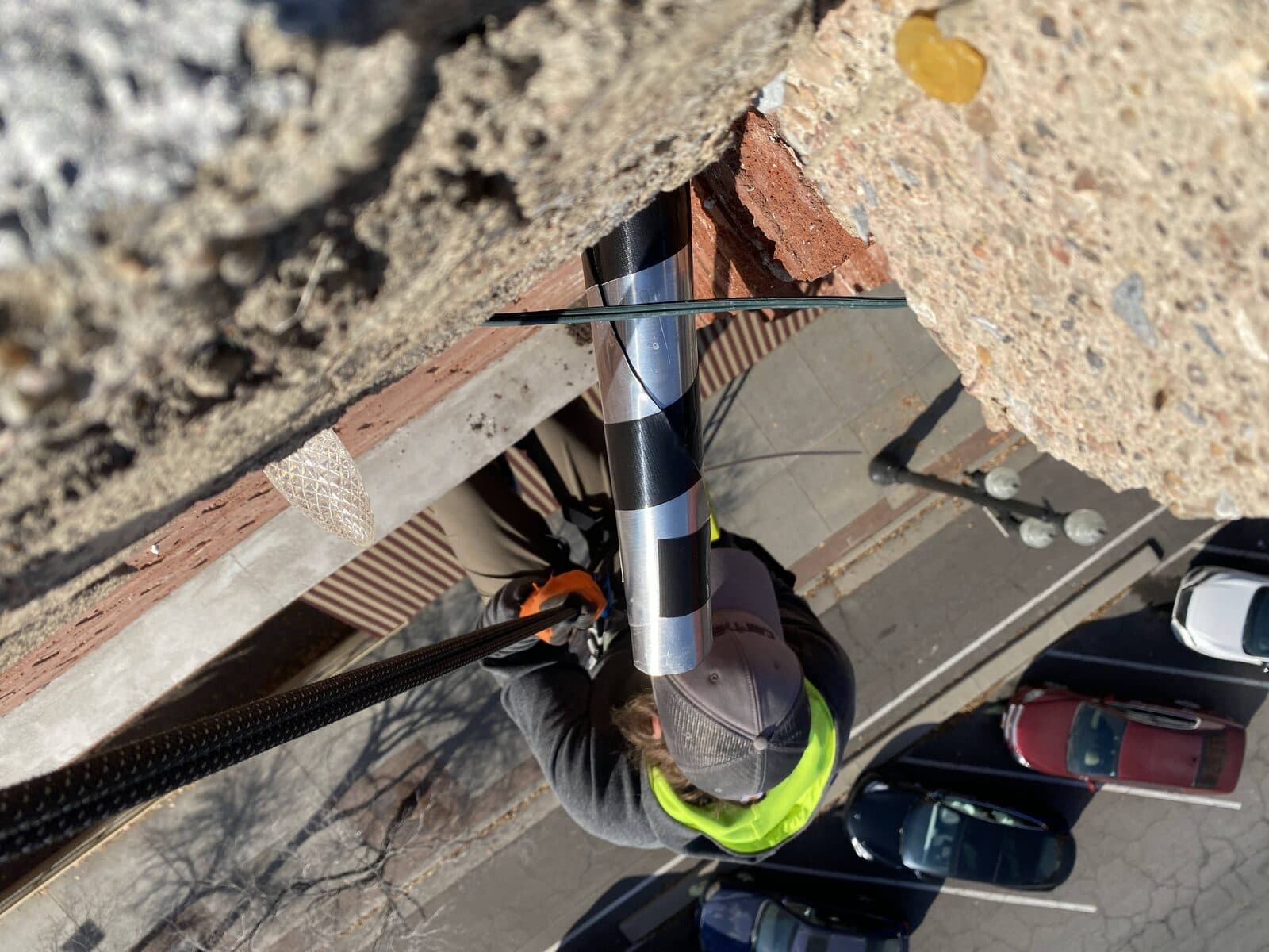 Rope-access technician installing a one-way exclusion tube
